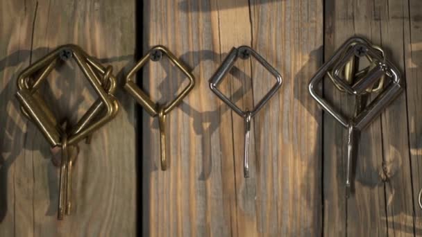Fivelas de metal diferentes penduradas na parede de madeira na oficina closeup — Vídeo de Stock