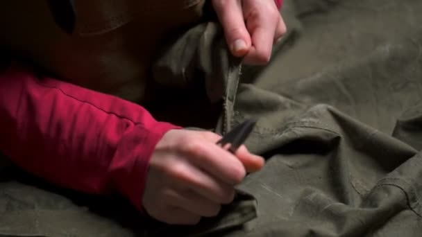 Жінка знімає тканину за допомогою гострих ножиць крупним планом повільний рух — стокове відео