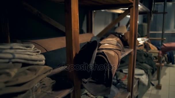 Ein Mann nimmt eine Stoffrolle aus einem Holzregal in der Werkstatt in Zeitlupe — Stockvideo