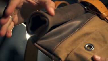 Bir adam yeni bir deri çanta deri kemer ve bir metal toka closeup ile kontrol