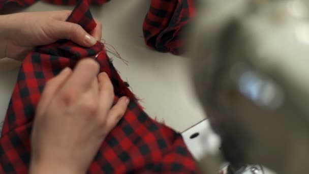 Молодая женщина отбирает кусок ткани с помощью потрошителя — стоковое видео
