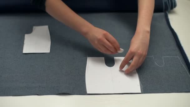 Hands of seamstress drawing the lines on the tissue with a piece of soap — Stock Video