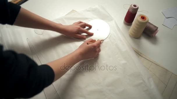 Junge Näherin zeichnet mit Bleistift und Lineal Linien auf weißem Papier — Stockvideo