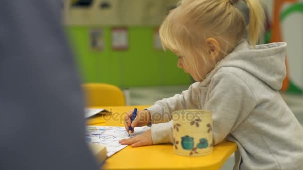 Menina bonito desenhando uma imagem colorida e sorrindo câmera lenta — Vídeo de Stock