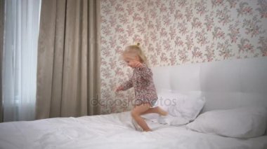 Yatağa çevrelerde çalıştıran ve yavaş hareket gülümseyen sevimli kız