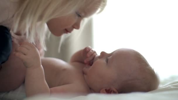 Hermosa niña besándose niña en la cama cámara lenta — Vídeos de Stock