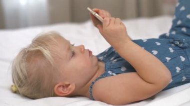 Smartphone onun elinde tutan ve oyunlar yavaş oynayan küçük kız