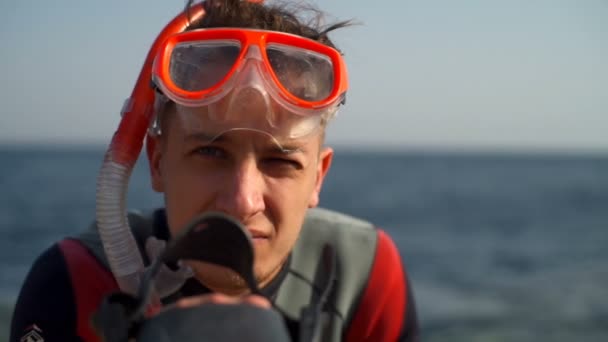 Человек в водолазном костюме смотрит на камеру замедленной съемки — стоковое видео