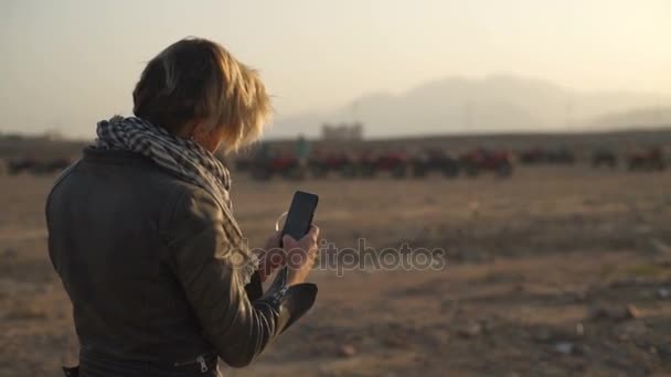 Mujer rubia linda tratando de hacer una selfie en el desierto mtoion lento — Vídeos de Stock