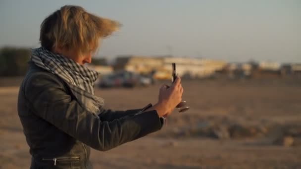 Menina loira fazendo uma selfie em um deserto câmera lenta — Vídeo de Stock