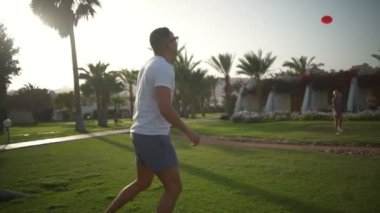 Adam gözlüklü bir frizbi özlüyor ama alır ve geri yavaş atar