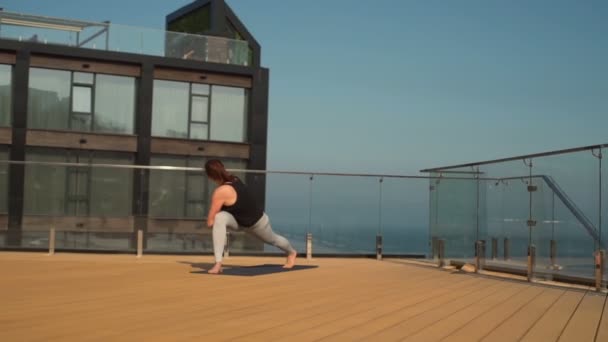 Mladá atraktivní žena dělá jógu na střeše na moři Zpomalený pohyb — Stock video