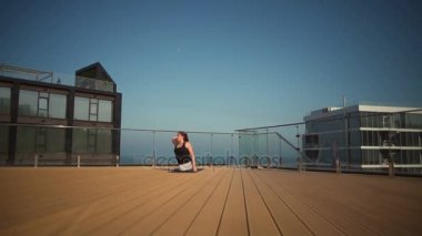 Deniz yavaş hareket, çatıda yoga yaparken genç çekici Bayan
