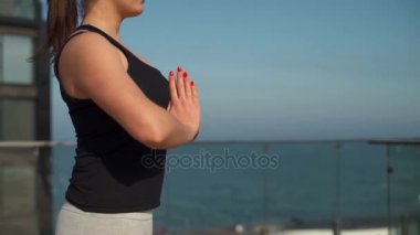 Genç çekici Bayan deniz yavaş hareket, çatıda meditasyon yapıyor