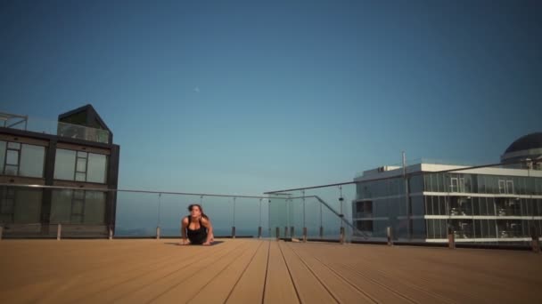 Joven atractiva hembra haciendo yoga en el techo en el mar cámara lenta — Vídeo de stock