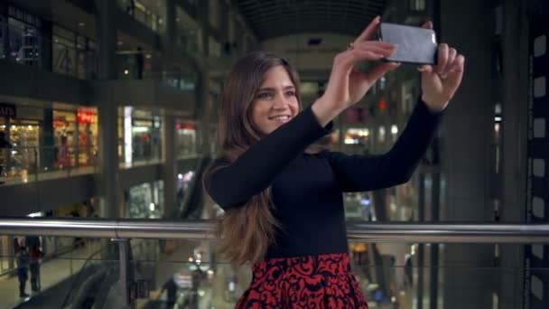 Beautiful young woman making a selfie in the mall slow motion — Stock Video