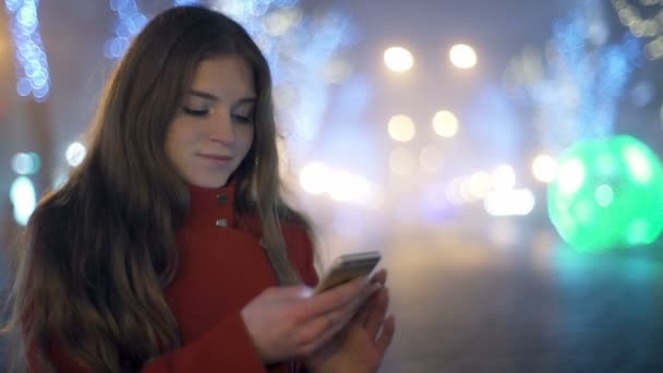 Красивая женщина использует свой смартфон на улице замедленной съемки — стоковое видео