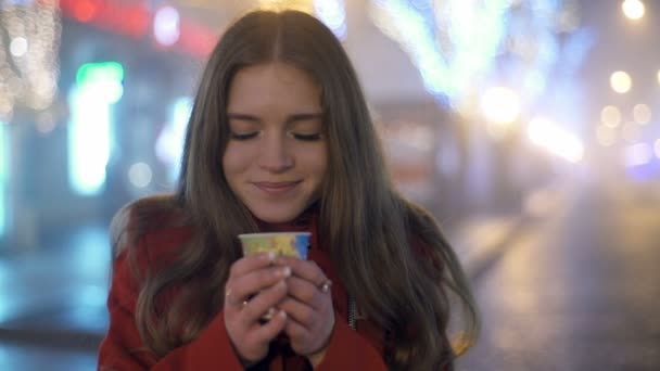 Jonge aantrekkelijke vrouw staande op de straat en het ruiken van een slowmotion koffie — Stockvideo