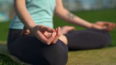 Genç kadın mat lotus poz siting ince ve yakın ağır çekim kadar meditasyon