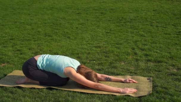 Mladé štíhlé ženské relaxaci po jógu na trávníku zpomalené — Stock video