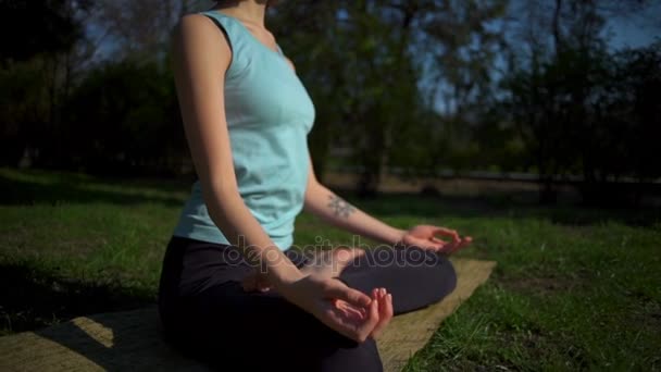 Joven hembra delgada haciendo namaste después de la pose de loto en el césped de cerca cámara lenta — Vídeos de Stock