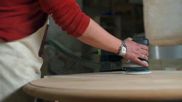 Carpenter fokozatosan polírozás egy kerek deszkát egy elektromos csiszoló, workshop — Stock videók