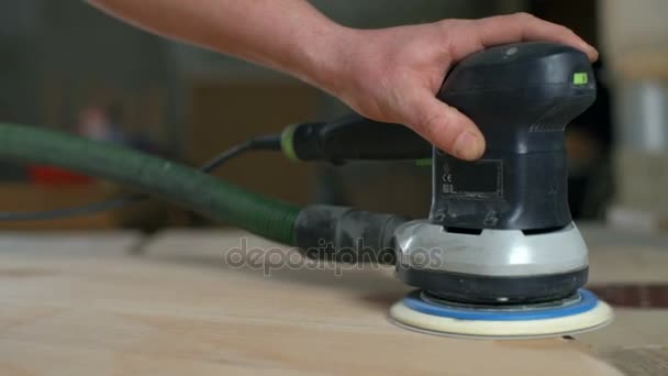 Carpintero puliendo una mesa de madera con una lijadora eléctrica en primer plano del taller — Vídeo de stock