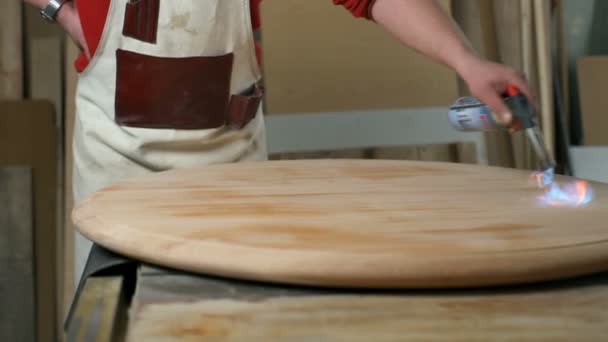 Asztalos lassan égetés a fából készült asztal, hogy változtatni a színét a Vértes műhely — Stock videók