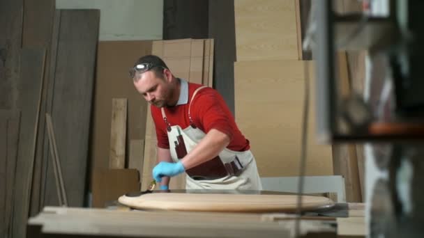 Плотник раскрашивает стол черным красителем в мастерской замедленной съемки — стоковое видео