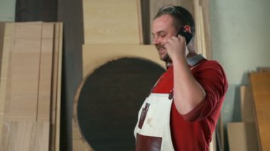 Bir şeyler açıklamaya ve atölye ağır çekimde telefonda konuşurken bir marangoz