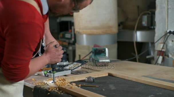 Carpinteiro faz um buraco no detalhe de madeira na oficina câmera lenta — Vídeo de Stock
