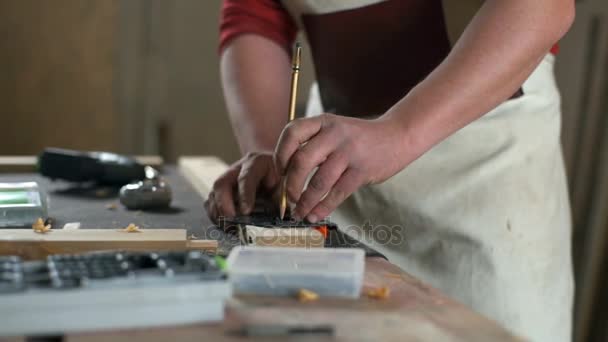 Carpenter, takže značky na kousek dřevěné prkno s tužkou v dílně — Stock video