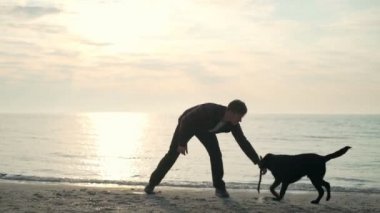 Genç erkek seslenmek odun parçasının deniz yavaş hareket getirmek için onun köpek