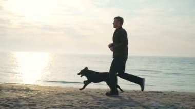 Genç erkek deniz yavaş hareket adlı köpeğiyle çalıştırmak