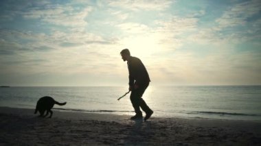 Genç erkek deniz yavaş hareket, yavru köpeğiyle oynuyor
