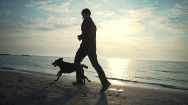 Genç erkek deniz yavaş hareket adlı köpeğiyle çalıştırmak