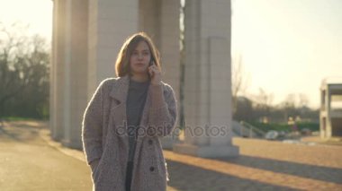 Genç kadın sokak ağır çekim üzerinde gülümseyen telefonda Sohbet