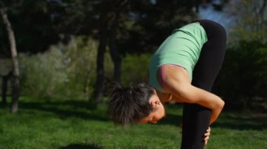 Park ağır çekimde sarı halı üzerinde uzanan genç güzel kadın