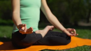 Lotus poz park ağır çekimde oturan güzel genç kadın