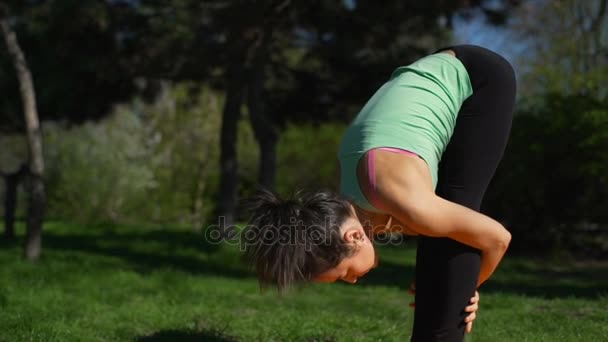 Giovane bella donna che si estende sul tappeto giallo nel parco rallentatore — Video Stock