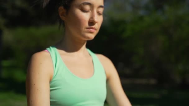 Mujer joven en forma meditando en la pose de loto en el bosque cámara lenta — Vídeos de Stock