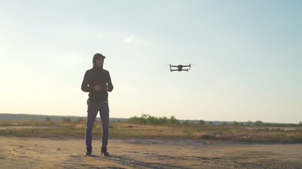 Pilota controlla il suo quadrocopter da remoto al rallentatore deserto colpo lungo — Video Stock