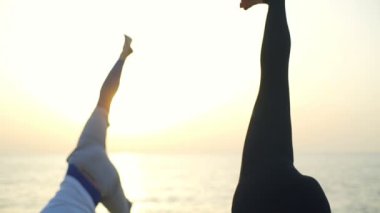 İki kişi kendi ayakları üzerinde ahşap iskele yavaş hareket yukarı çeker