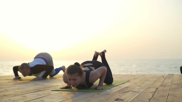 Tres amigos hacen ejercicios de yoga en el muelle de madera en cámara lenta — Vídeo de stock