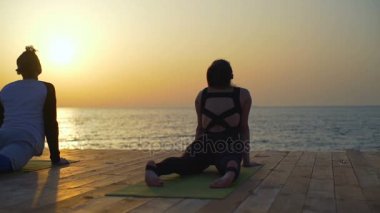 Yalan ve deniz ağır çekim yakınındaki yeşil halı uzanan üç kişi