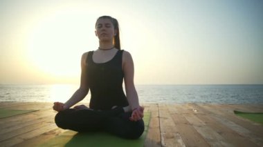 Lotus poz ahşap Teras yavaş hareket üzerinde oturan güzel kadın