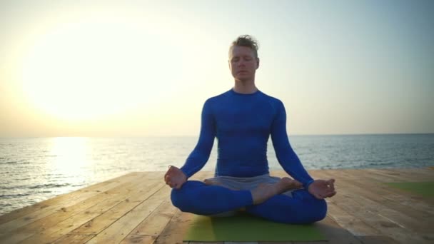 Hombre sentado en la pose de loto cerca del mar cámara lenta — Vídeos de Stock