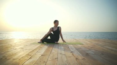 Güzel kadın bir yoga yapmak egzersiz ahşap iskele ağır çekim