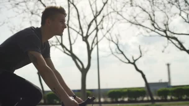 Guay hombre tatuado guapo montando su bicicleta en la calle cámara lenta — Vídeos de Stock