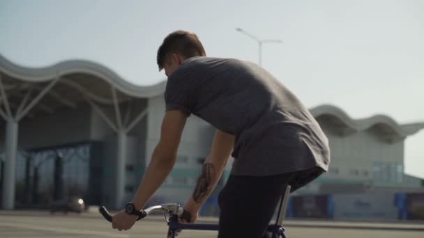 Man zijn fiets voor een groot gebouw slow motion — Stockvideo